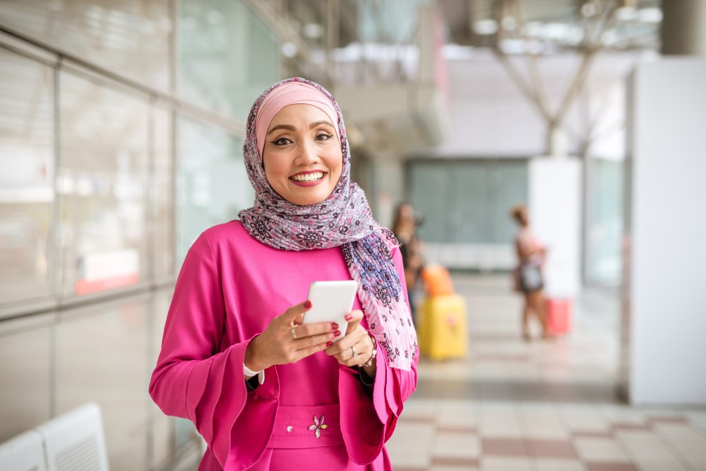 Wanita sedang menggunakan aplikasi manajemen tim clinic kumoSan di ponselnya.