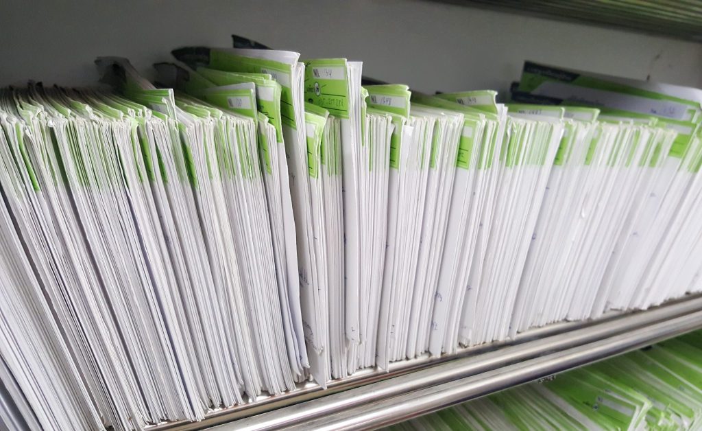 Proses manual di klinik kecantikan membuat kertas dan berkas menumpuk